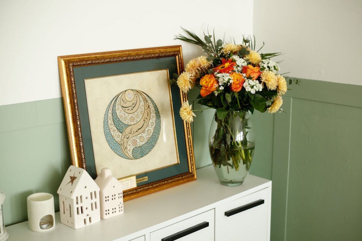 A stylish interior with a framed artwork and a bouquet of flowers, creating a warm atmosphere.